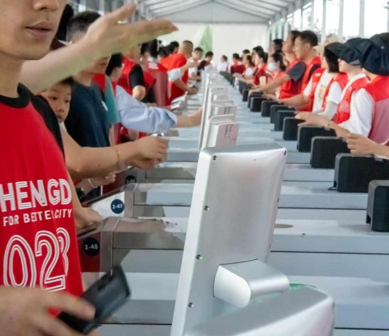 赛事入口多台闸机并排部署，观众在现场进行票证核验